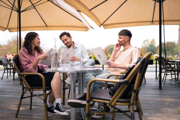 Amis souriants au restaurant plein coup