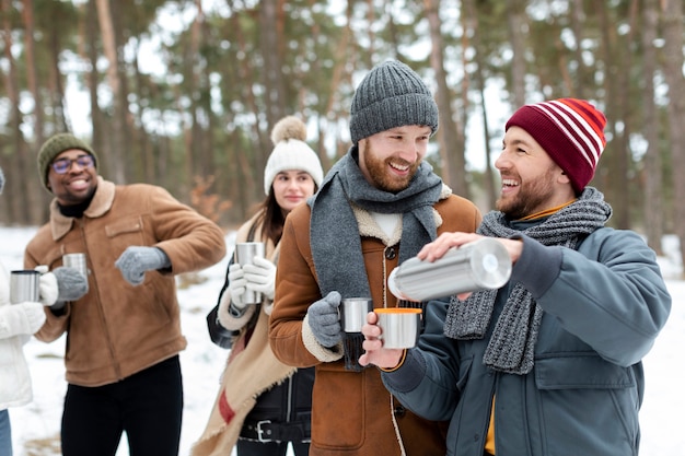 Photo gratuite amis souriants à coup moyen avec boisson chaude