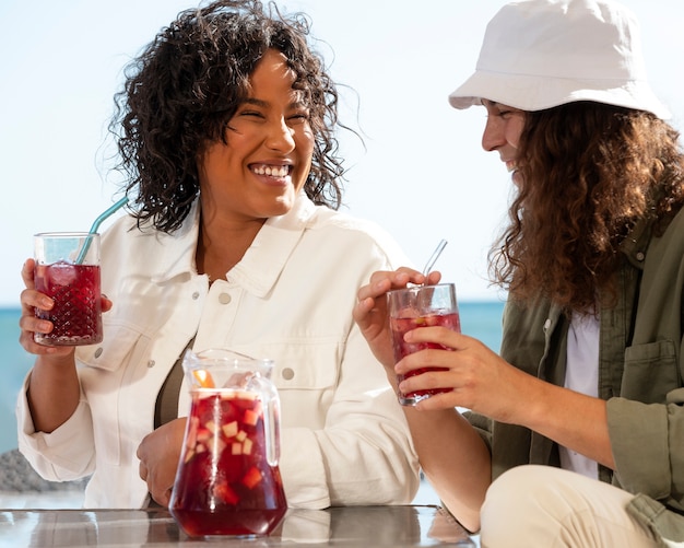 Amis souriants à coup moyen avec des boissons à la sangria