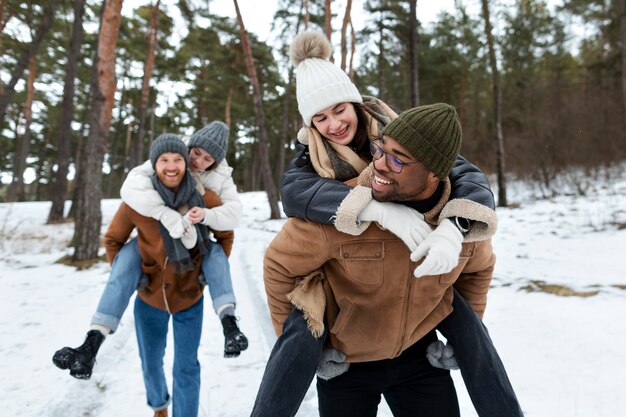 Amis souriants à coup moyen, heure d'hiver