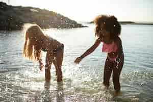 Photo gratuite amis souriants sur la plage plein coup