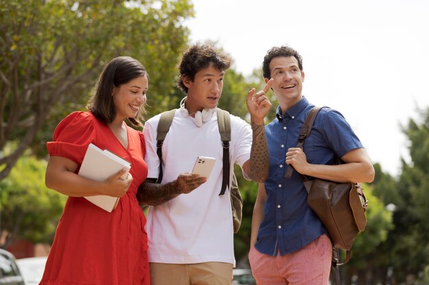 Amis souriants de plan moyen à l'extérieur