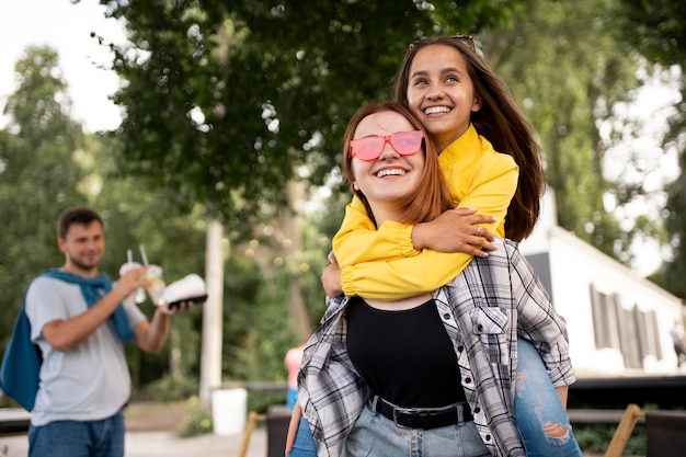 Amis souriants de plan moyen à l'extérieur