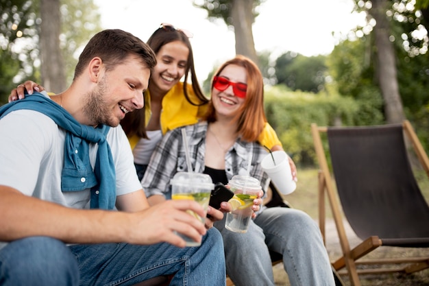 Amis souriants de plan moyen à l'extérieur