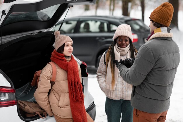 Amis souriants de plan moyen à l'extérieur