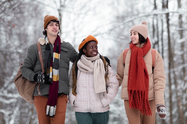 Amis souriants à plan moyen, heure d'hiver