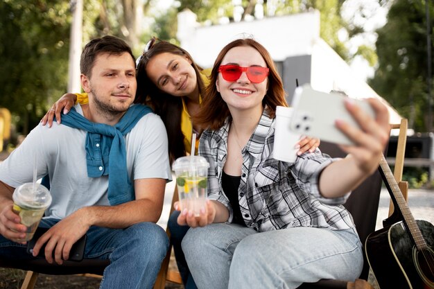 Amis souriants de plan moyen prenant un selfie