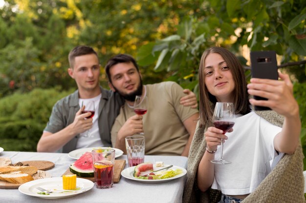 Amis souriants de plan moyen prenant un selfie