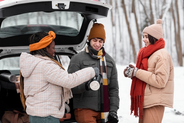 Photo gratuite amis souriants à plan moyen saison d'hiver