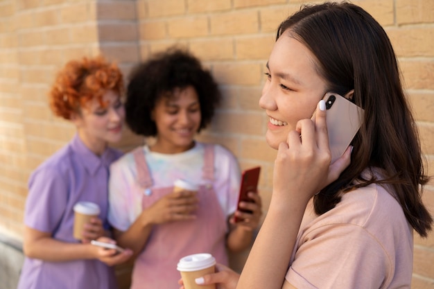 Amis souriants de plan moyen avec des smartphones