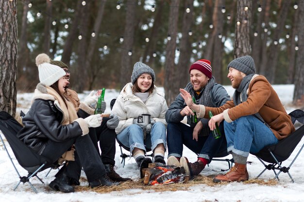 Amis souriants plein coup avec des bouteilles de bière