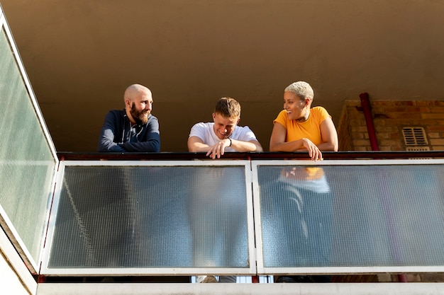 Photo gratuite amis souriants en plein plan sur le balcon