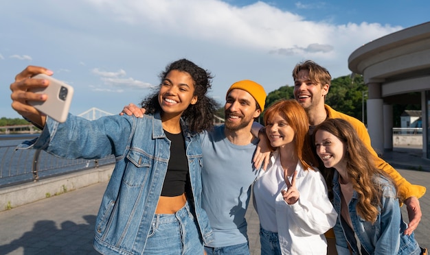 Amis souriants prenant selfie ensemble coup moyen