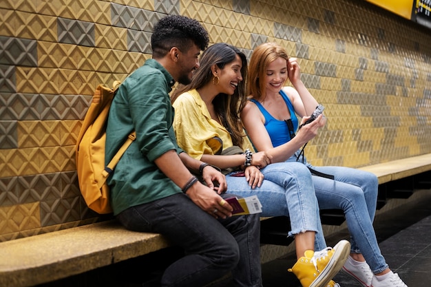 Amis souriants vue de côté assis ensemble