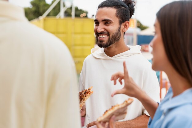 Amis souriants à la vue latérale du festival gastronomique