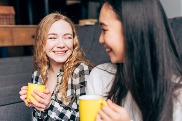 Amis avec des tasses à thé souriant