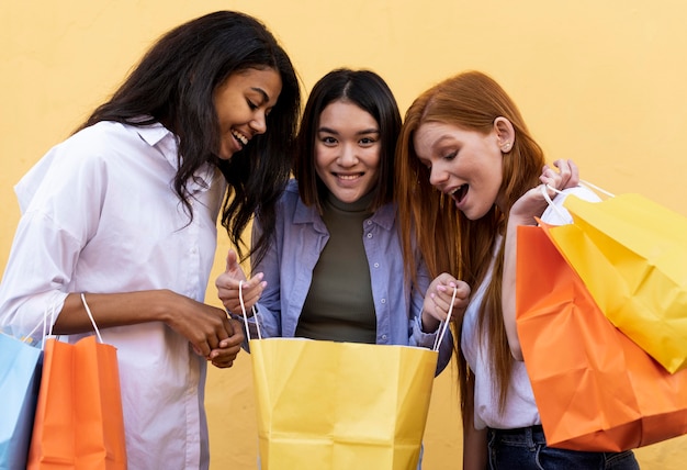 Photo gratuite amis tenant des sacs à provisions à l'extérieur