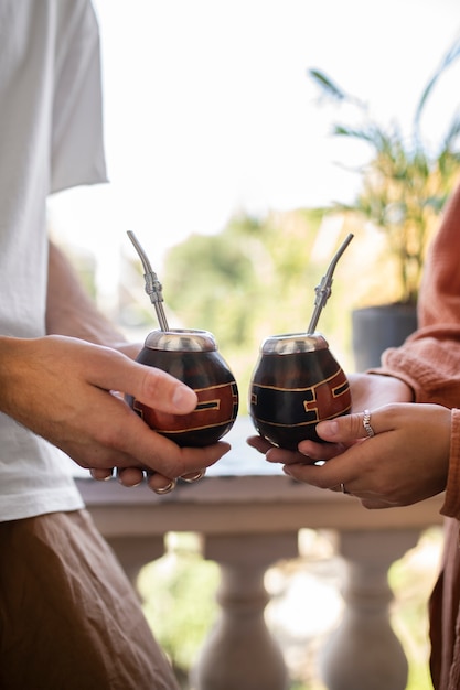 Amis tenant des tasses vue de côté