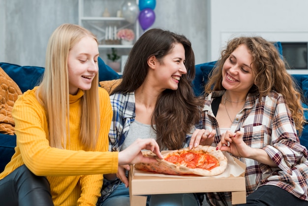 Amis en train de manger une pizza