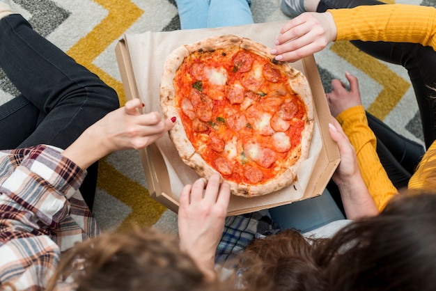 Amis en train de manger une pizza