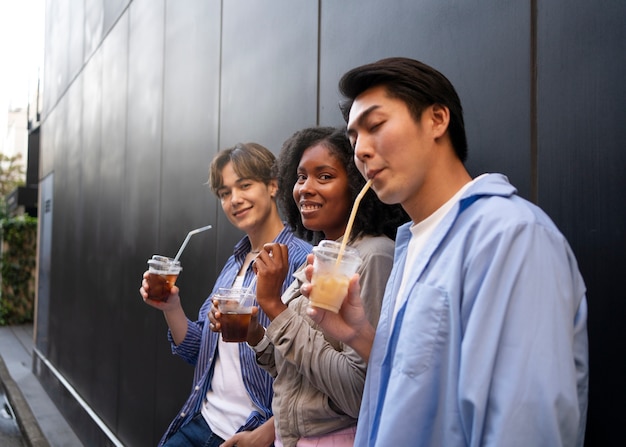 Photo gratuite amis vue de côté buvant du café glacé