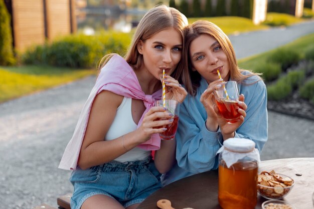 Amis vue de face avec un délicieux kombucha à l'extérieur