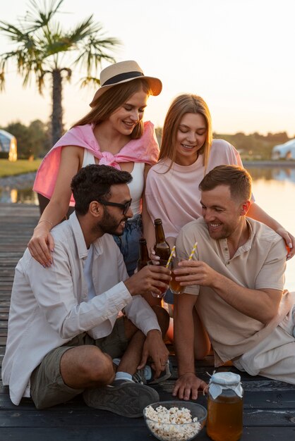 Amis vue de face avec un délicieux kombucha à l'extérieur