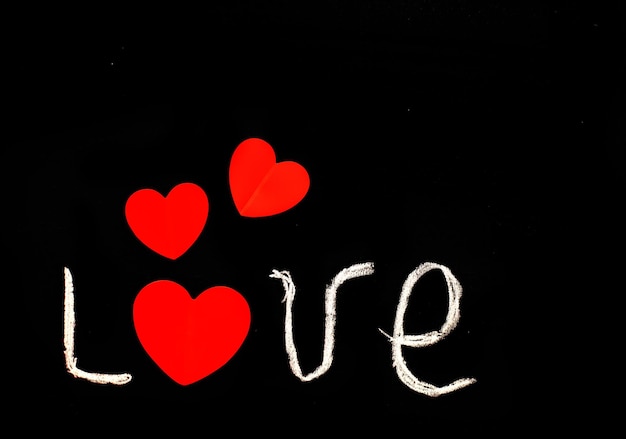 L'amour d'inscription sur le tableau noir avec des coeurs. salutation pour la saint valentin