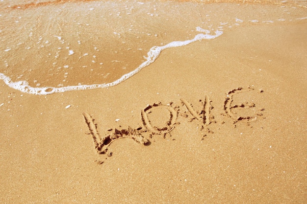 Photo gratuite l'amour inscrit dans le sable d'une plage