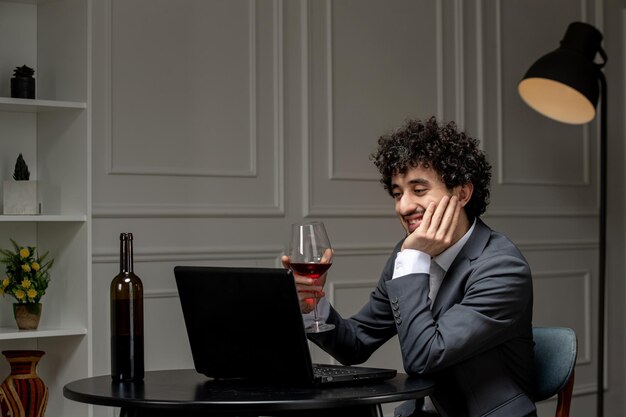 Amour virtuel beau mec mignon en costume avec du vin sur une date d'ordinateur à distance pensant souriant