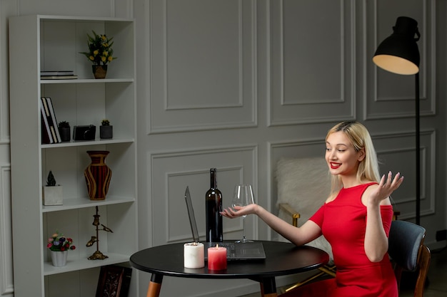 Amour virtuel jolie fille blonde en robe rouge à distance date avec du vin et des bougies en agitant les mains