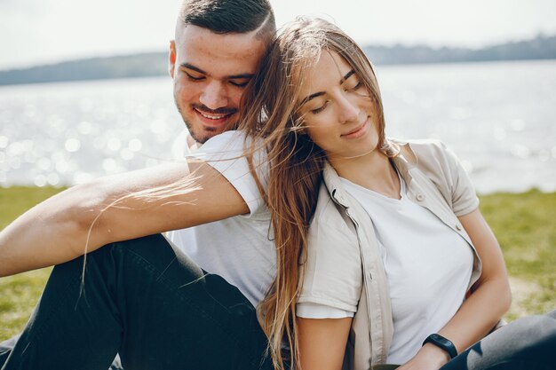 Les amoureux tendres et joyeux s&#39;amusent au bord du lac avec un chien