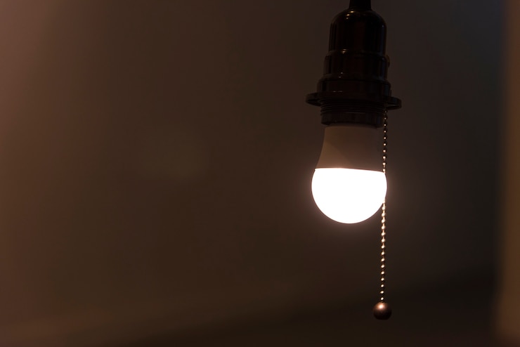 Photo gratuit une ampoule lumineuse suspendue dans une pièce
