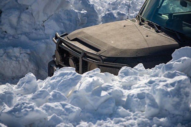 Amusement de conduite de voiture tout-terrain sur une route enneigée. voiture tout-terrain sur la route d'hiver de neige. expédition hors route en jeep sur la route de montagne.