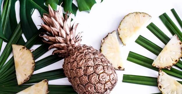 Ananas aux feuilles tropicales sur fond blanc