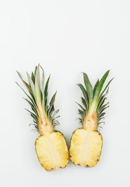 Ananas de bon goût coupé en deux sur un blanc. vue de dessus.