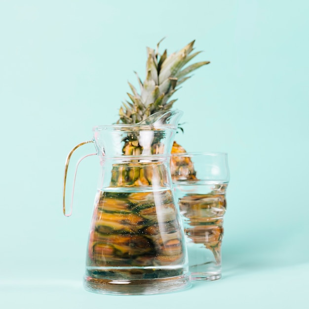 Photo gratuite ananas derrière une cruche d'eau