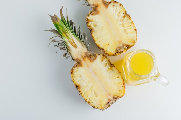 Ananas avec du jus sur une surface blanche