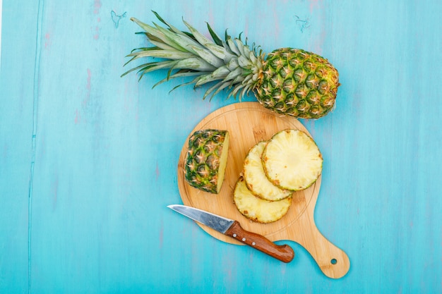 Ananas Entier Et Tranché Dans Une Planche à Découper Avec Un Couteau à Fruits Vue De Dessus Sur Un Cyan Bleu