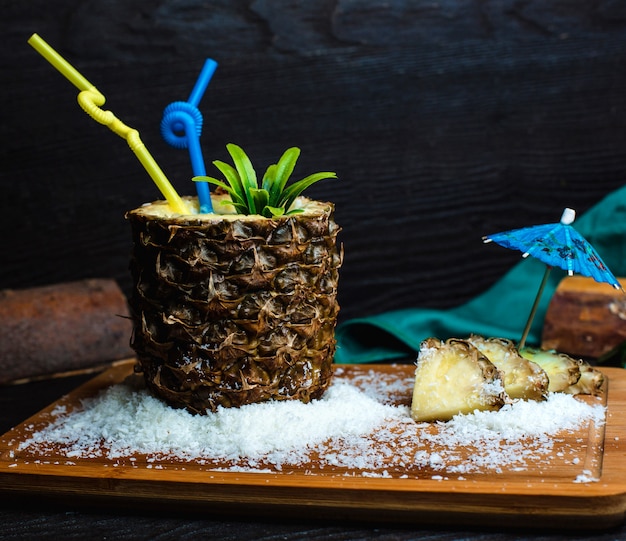 Ananas frais sur une planche de bois avec de la noix de coco