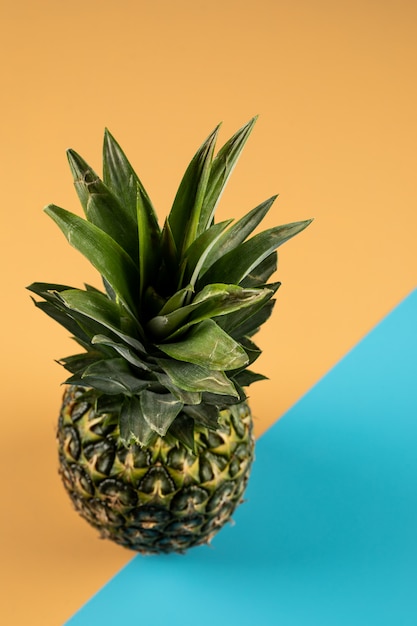 Photo gratuite ananas sur un mur de couleur bleu orange, vue de dessus