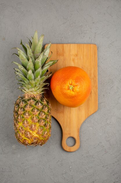 Ananas orange frais mûr sur un bureau en bois brun