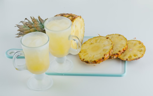 Ananas en tranches avec des jus sur une planche à découper