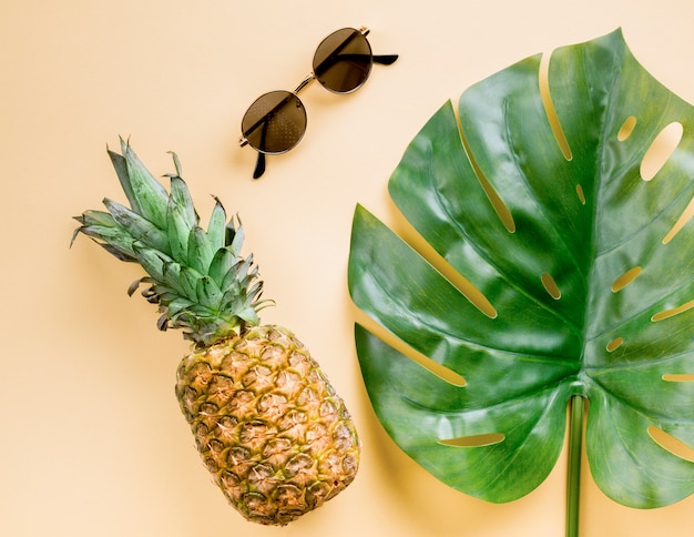 Ananas vue de dessus avec lunettes de soleil et feuille