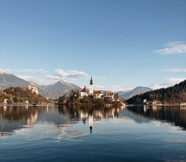 Ancien château entouré d'un paysage montagneux se reflétant dans le lac