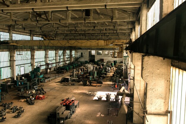 Ancien hall d'usine avec du matériel, des machines et des ouvriers