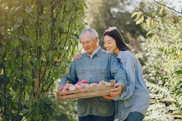 Ancien senior debout dans un jardin d'été avec récolte