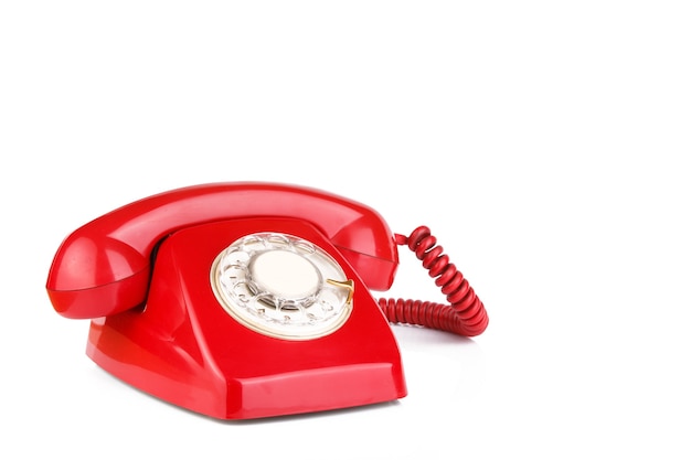 Ancien téléphone de couleur rouge isolé sur surface blanche
