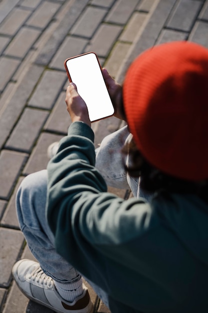 Angle élevé d'adolescent à l'extérieur à l'aide de smartphone