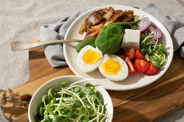 Angle élevé d'assiette avec des aliments diététiques céto et un bol avec des germes